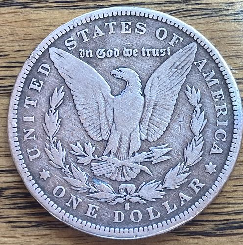 1882S Morgan silver dollar in VERY GOOD condition slightly bent see photo